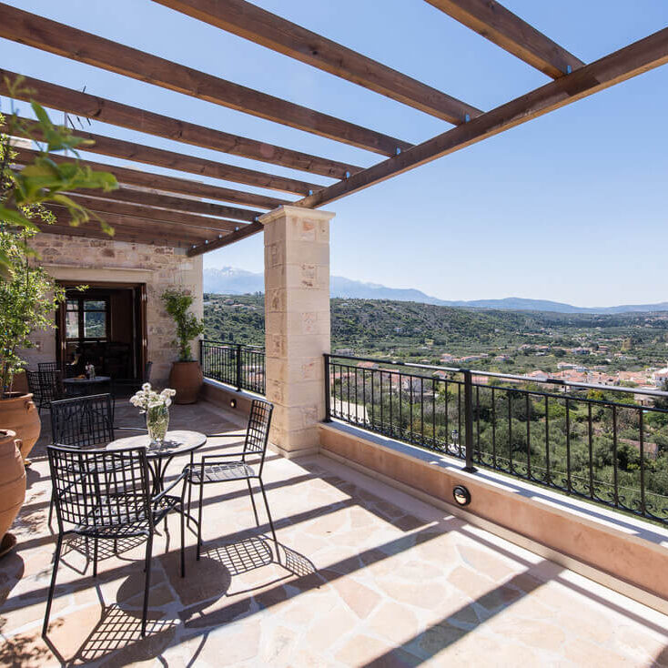 A patio with chairs and tables on the side of it.